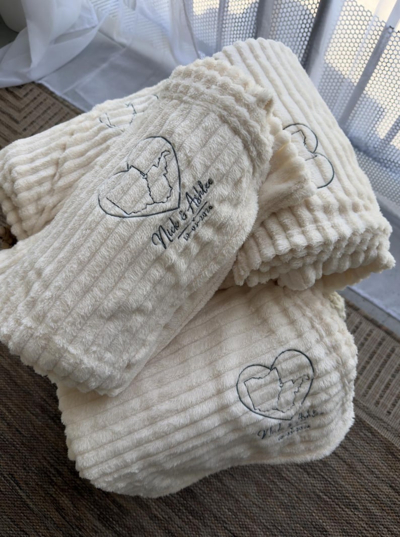 Cream ribbed blanket embroidered with a heart map outline, couple's names and wedding date